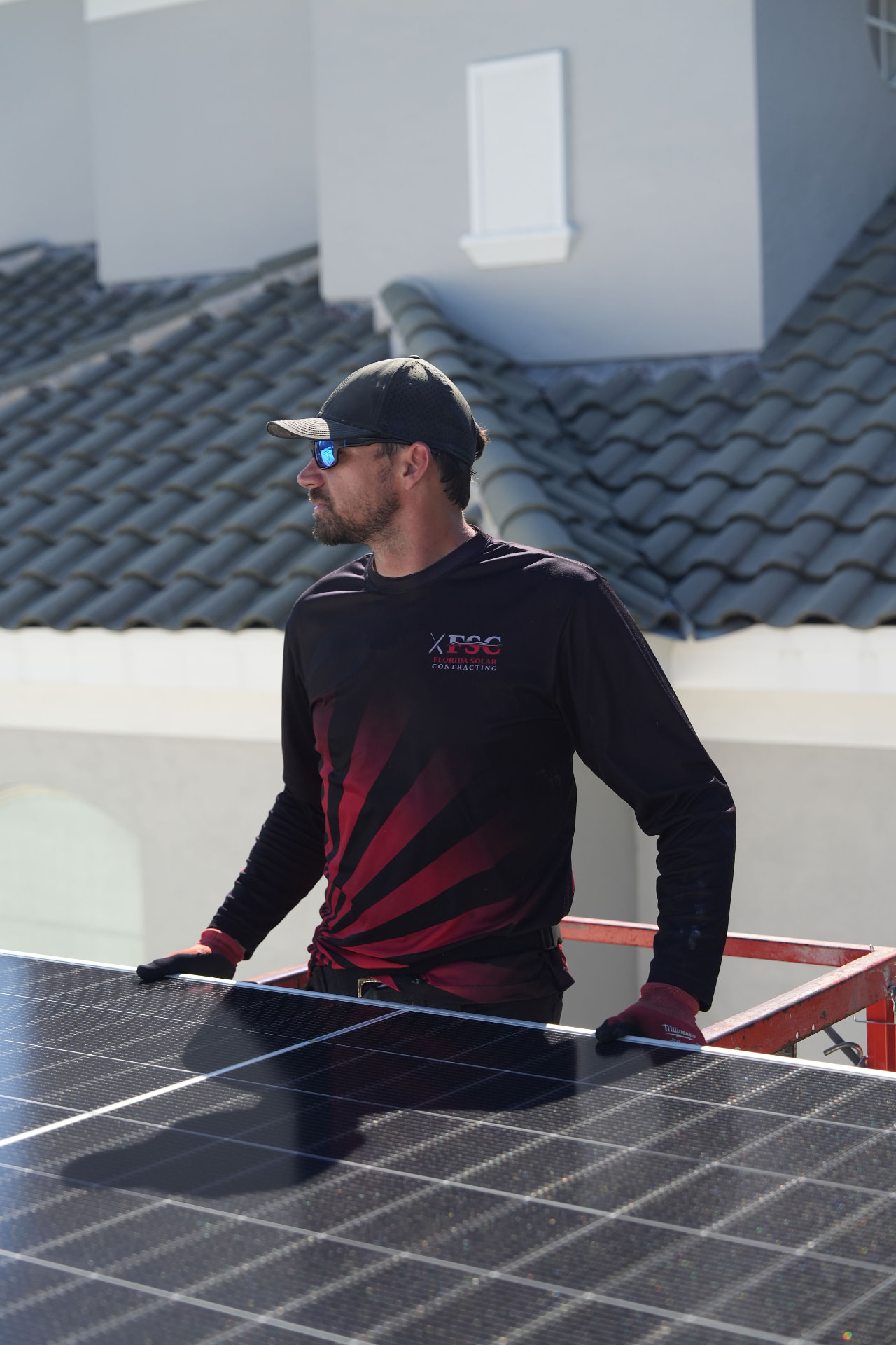 FSC technician beside a rooftop solar array